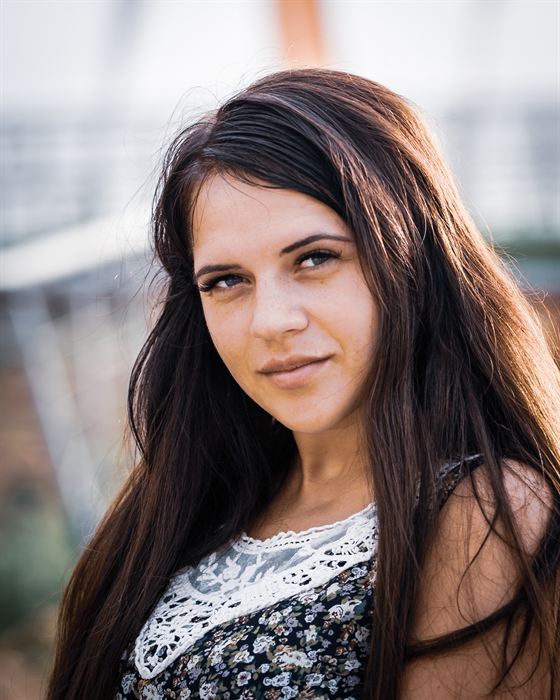 Portrait of a young woman with long dark hair in warm evening light