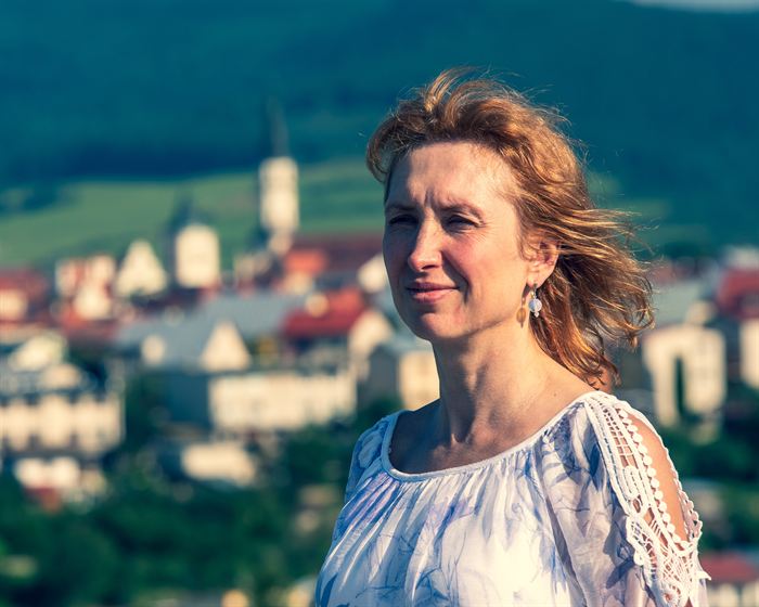 Portrait of a woman with wind-blown hair, a small town out of focus below