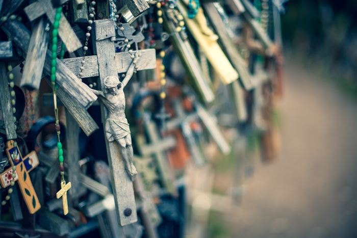 Wooden crucifixes and rosaries hung densely together at the Hill of Crosses, Lithuania